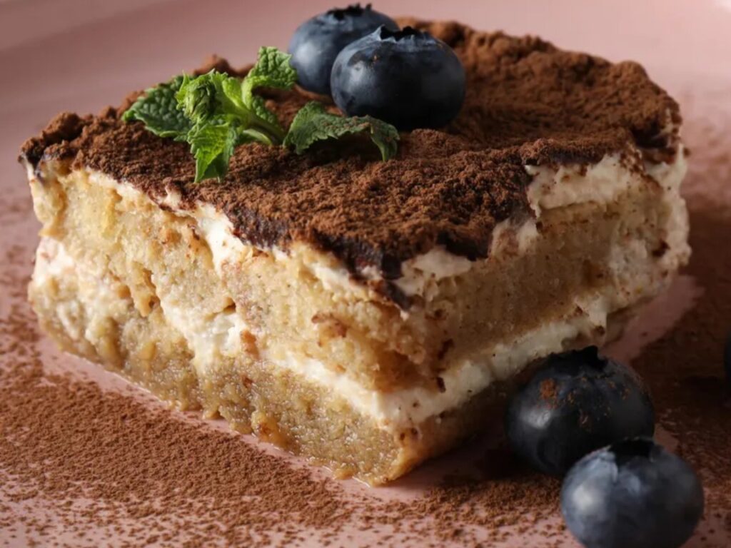 A classic Italian tiramisu with layers of espresso-soaked ladyfingers, mascarpone cream, and cocoa dusting.