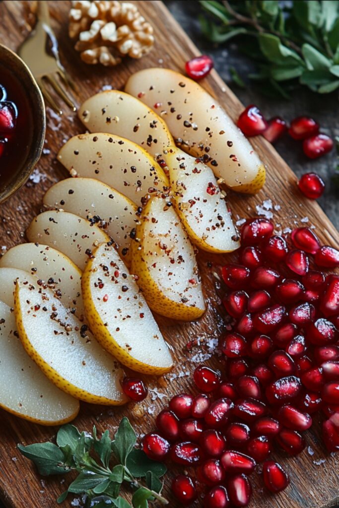 A close-up of fresh ingredients for Festive Pomegranate Pear Delight, including sliced pears, pomegranate arils, and walnuts, beautifully arranged on a wooden cutting board.